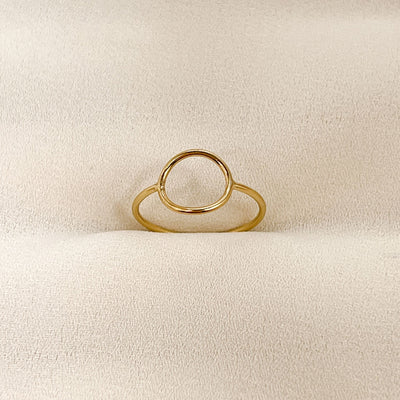 highly polished, dainty 14KGF hollow circle stacking ring displayed on cream coloured fabric