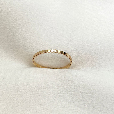 14K Gold filled dot ring on cream coloured background. The dot ring is a series of uniform gold circles joined together to create a circle finger ring. Highly polished giving a glorious shine