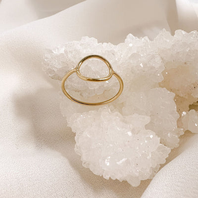 highly polished, dainty 14KGF hollow circle stacking ring displayed on  white crystal geode