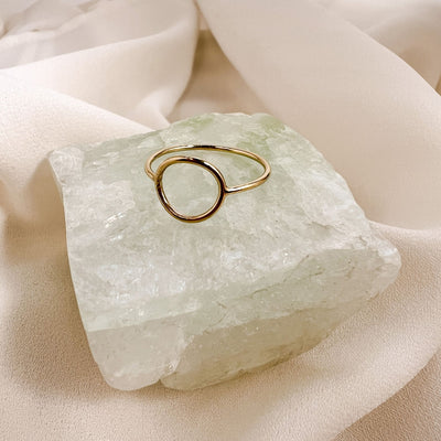 highly polished, dainty 14KGF hollow circle stacking ring displayed on aqua colour gemstone