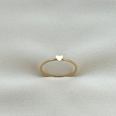 14K Gold filled simple band ring with tiny 2mm cut out heart shape on top. Gold heart ring is on cream coloured fabric