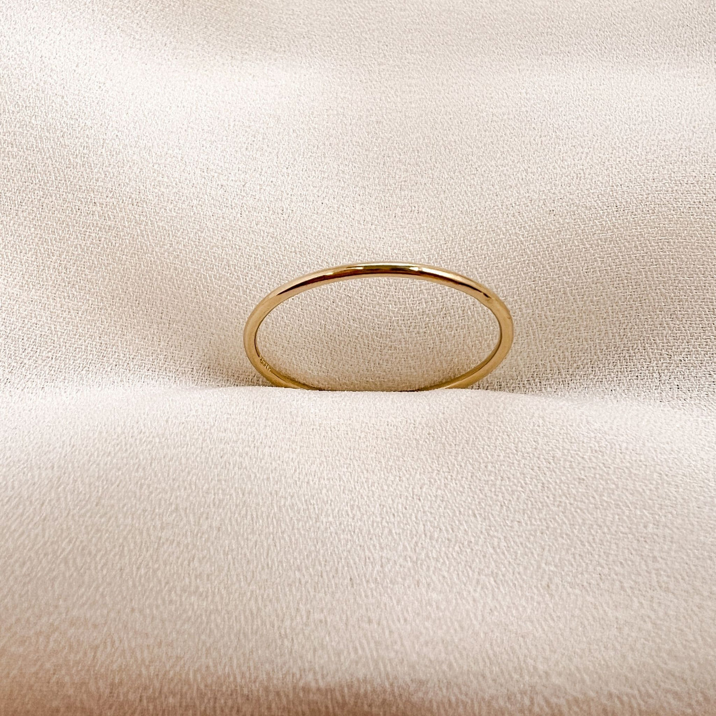 Simple 14Kgold filled 1mm band ring on cream coloured fabric