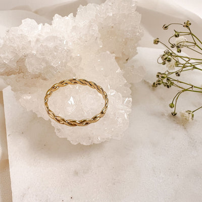 Highly polished 14K gold filled double braided women's stacking ring displayed on  sparkly white crystal geode