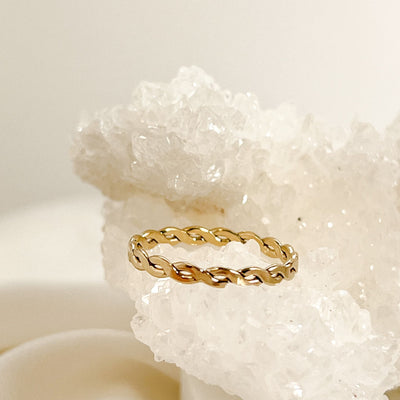 Highly polished 14K gold filled double braided women's stacking ring displayed on sparkly white crystal geode