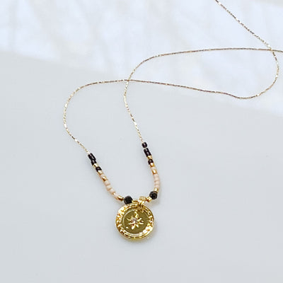 18k gold plated super thin chain necklace with 3 inches of beads at centre with a shiny gold 1/4" circle pendant with a cubic zirconia star centre.