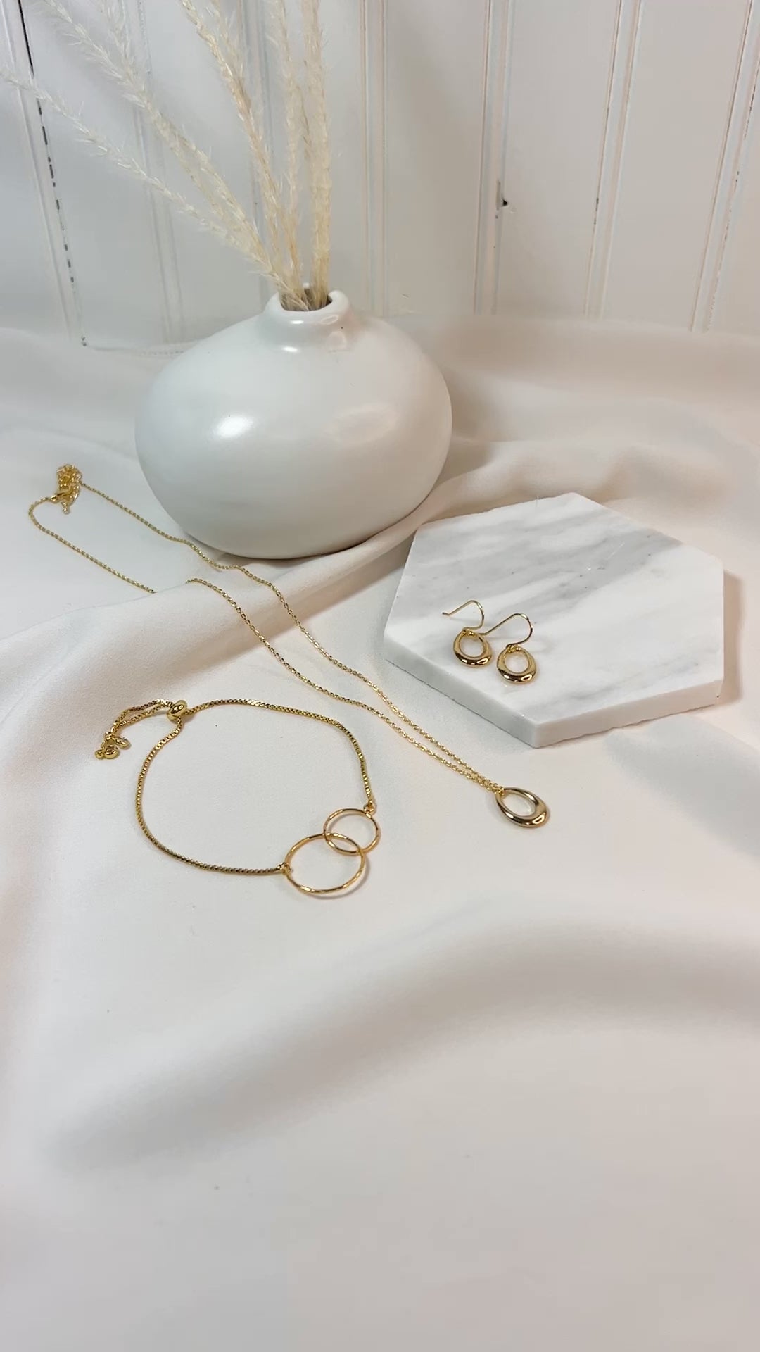 Video featuring Reminded Designs Mini Spring Jewelry Bundle featuring a simple gold necklace with matching earrings and an adjustable bolo style bracelet